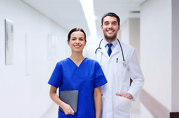 Image showing smiling doctor in white coat and nurse at hospital