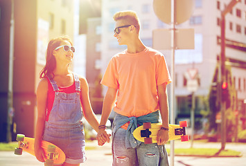 Image showing teenage couple with skateboards on city street