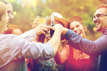 Image showing happy friends clinking glasses at summer garden