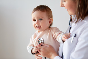 Image showing doctor with stethoscope listening baby at clinic