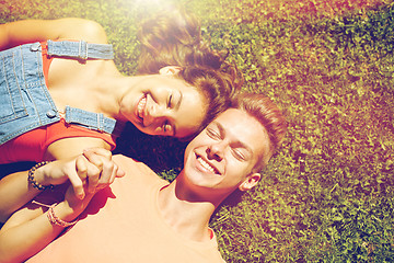 Image showing happy teenage couple lying on grass at summer