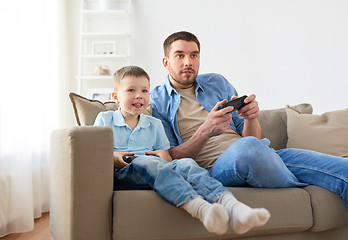 Image showing father and son playing video game at home