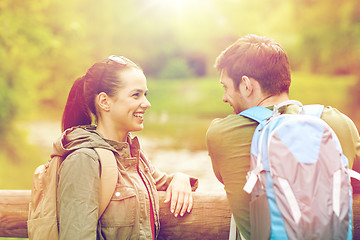 Image showing smiling couple with backpacks in nature