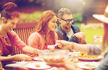 Image showing happy friends having dinner at summer garden party