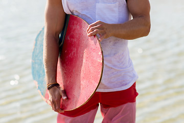 Image showing close up of man with skimboard on summer beach