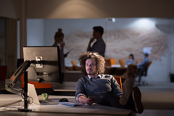 Image showing businessman sitting with legs on desk at office