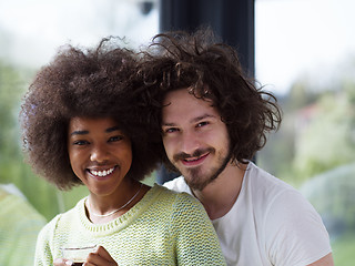 Image showing happy multiethnic couple relaxing at modern home indoors