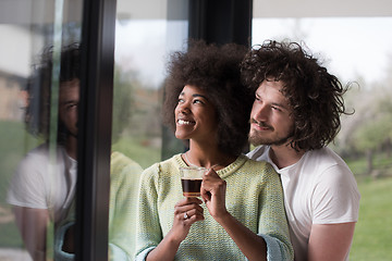 Image showing happy multiethnic couple relaxing at modern home indoors