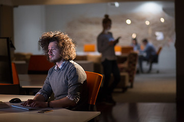 Image showing man working on computer in dark office