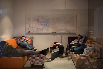 Image showing software developers sleeping on sofa in creative startup office