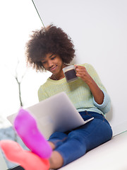 Image showing black woman in the living room on the floor