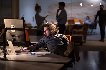 Image showing businessman sitting with legs on desk at office