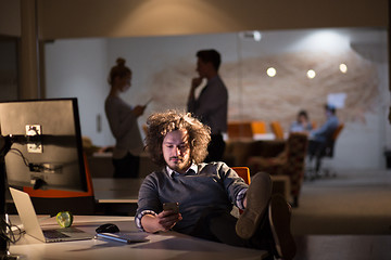 Image showing businessman sitting with legs on desk at office