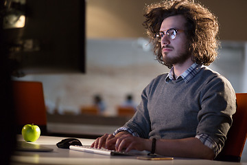 Image showing man working on computer in dark office