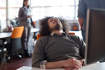 Image showing young businessman relaxing at the desk