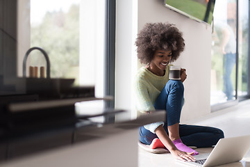 Image showing black woman in the living room on the floor