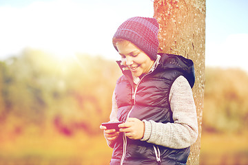 Image showing happy boy playing game on smartphone outdoors