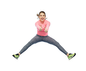 Image showing happy smiling sporty young woman jumping in air