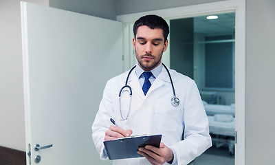 Image showing doctor writing to clipboard at hospital