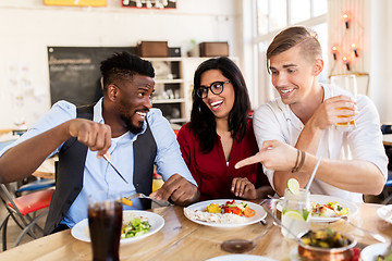 Image showing happy friends eating and having fun at restaurant