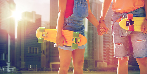 Image showing close up of young couple with skateboards in city