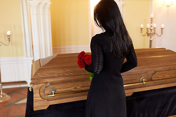 Image showing woman with red roses and coffin at funeral