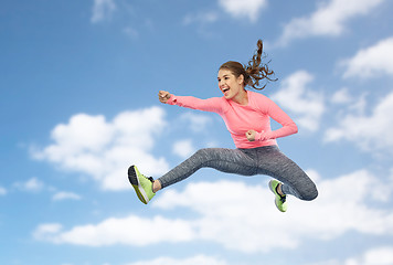 Image showing happy sporty young woman jumping in fighting pose