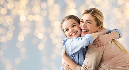 Image showing happy girl with mother hugging over lights