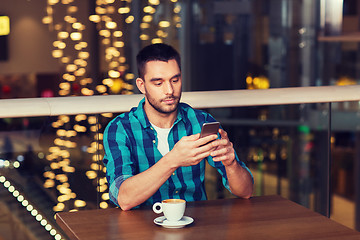 Image showing man with smartphone and coffee at restaurant