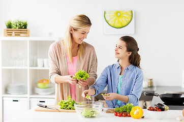 Image showing happy family cooking salad at home kitchen