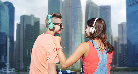 Image showing teenage couple with headphones on river berth