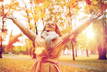 Image showing happy woman having fun with leaves in autumn park