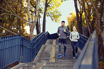 Image showing happy couple running downstairs in city