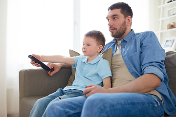 Image showing father and son with remote watching tv at home