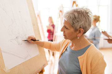 Image showing woman artist with pencil drawing at art school