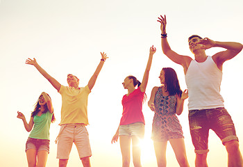 Image showing smiling friends dancing on summer beach