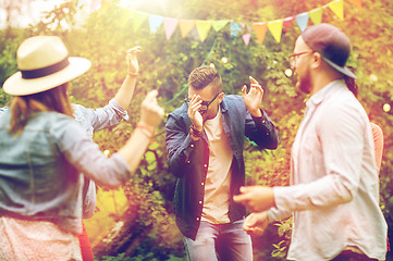 Image showing happy friends dancing at summer party in garden