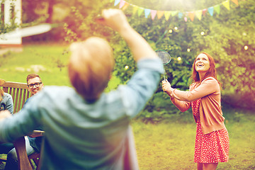 Image showing happy friends playing badminton at summer garden