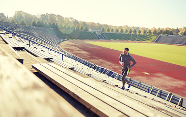 Image showing happy young man running upstairs on stadium