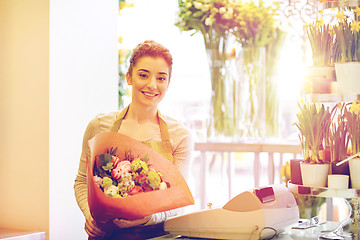 Image showing smiling florist woman with bunch at flower shop