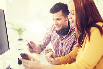 Image showing happy creative team with smartphones at office