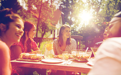 Image showing happy friends having dinner at summer garden party