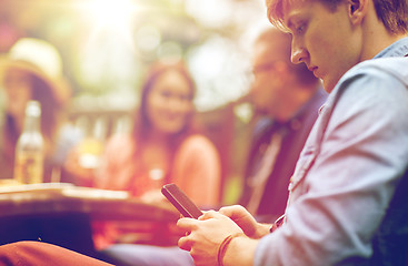 Image showing man with smartphone and friends at summer party