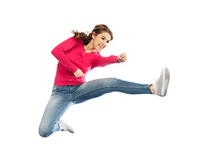 Image showing smiling young woman jumping in air