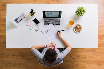 Image showing woman with laptop and papers at office table