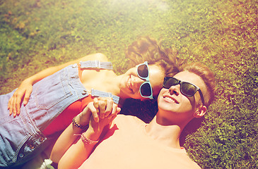 Image showing happy teenage couple lying on grass at summer