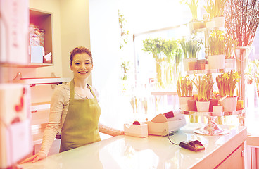 Image showing happy smiling florist woman at flower shop counter