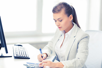 Image showing businesswoman with notebook and calculator