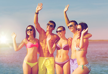 Image showing smiling friends in sunglasses on summer beach