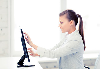 Image showing smiling businesswoman with touchscreen in office